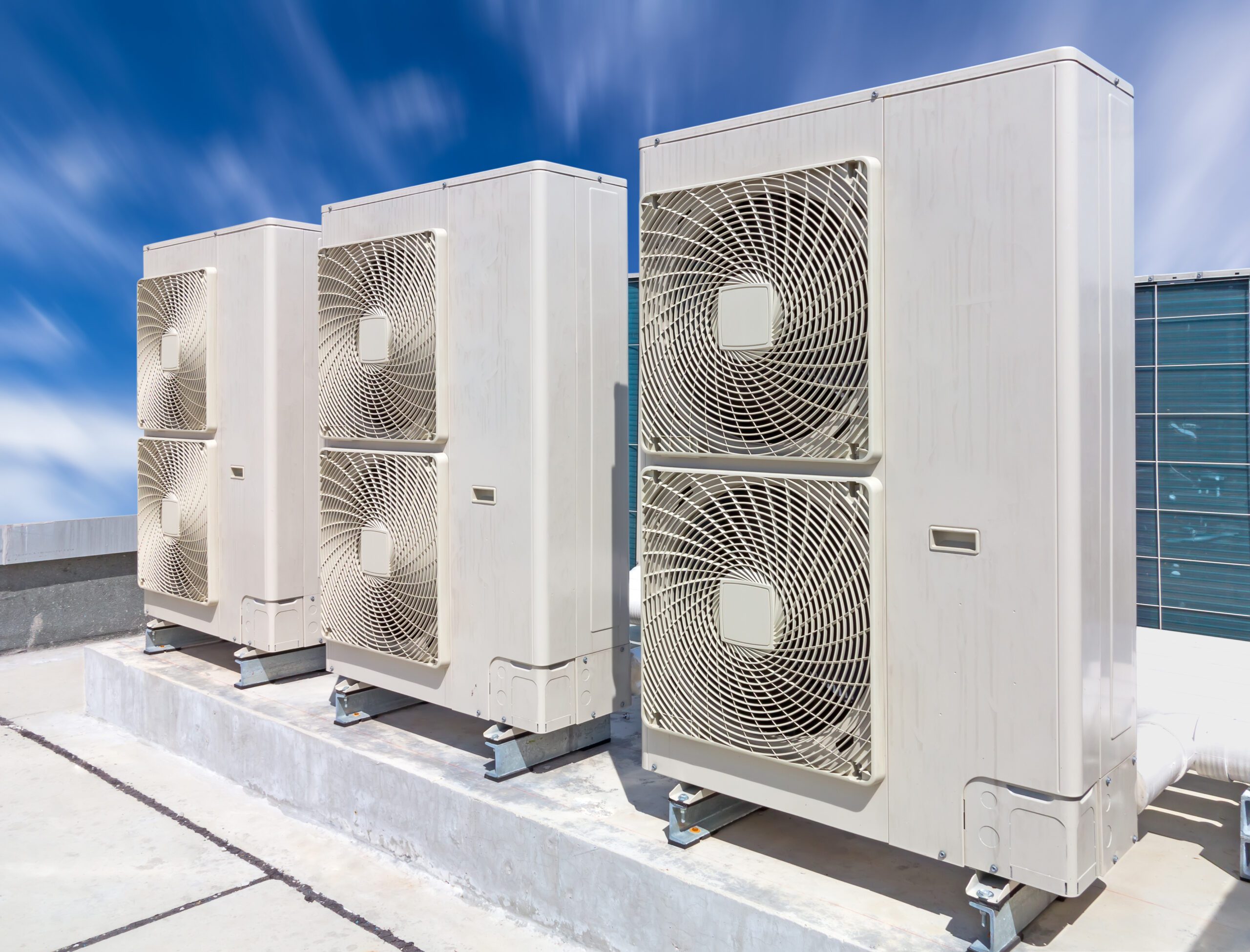 Air compressor on pedestal with blue sky background.